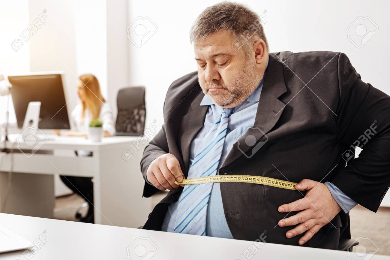 hardworking employee suffering from excess weight stock photo hard working employee