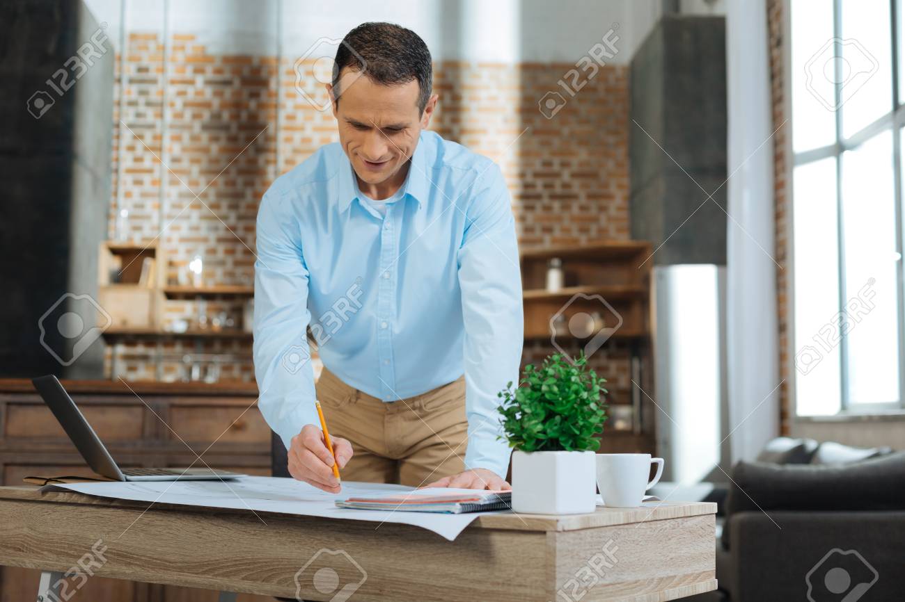 Alle Gerate Verwenden Nette Mannliche Person Die Abwarts Beim Zeichnen Der Projektarbeit Lehnend Auf Tabelle Schaut Lizenzfreie Fotos Bilder Und Stock Fotografie Image