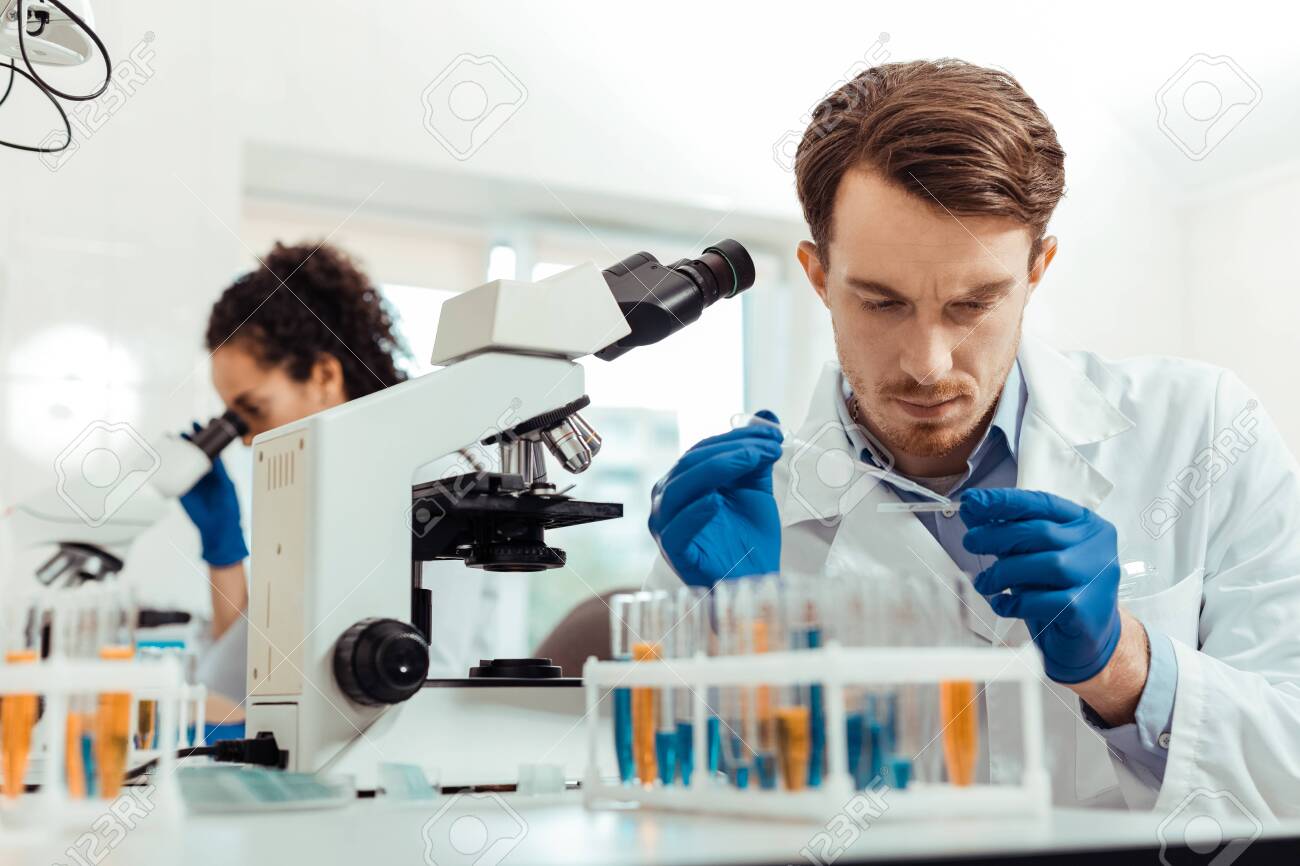 Biological lab. Smart young man being in the lab while working as a biologist - 127134521 Biological lab. Smart young man being in the lab while working as a biologist - 127134521