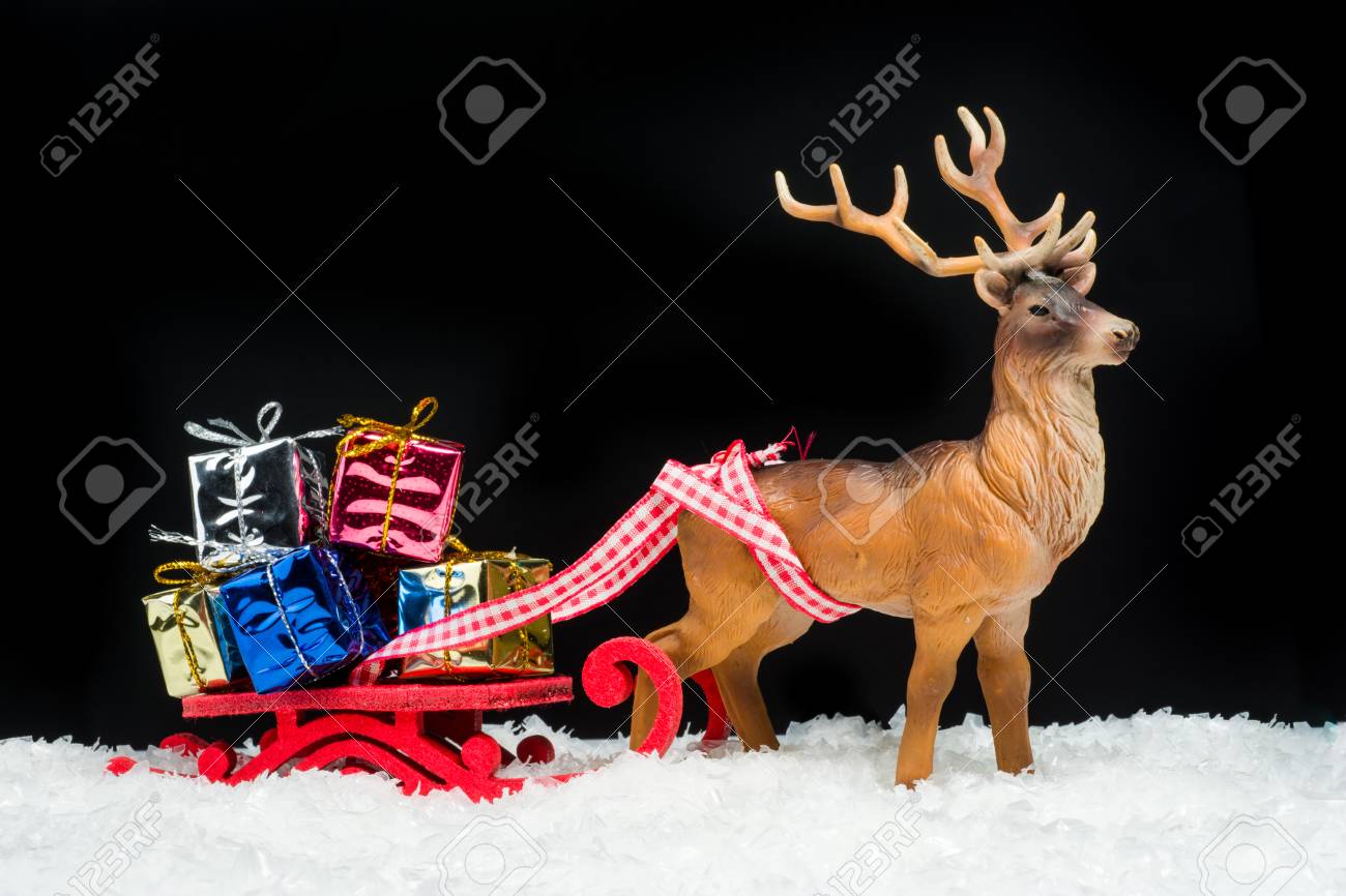 赤いクリスマス ギフト ボックスと黒の背景上のトナカイそり の写真素材 画像素材 Image