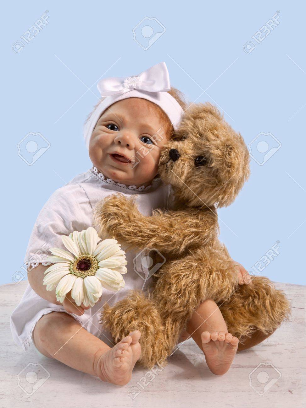 赤ん坊の人形を抱きしめると花と床の座っているテディー ベア の写真素材 画像素材 Image