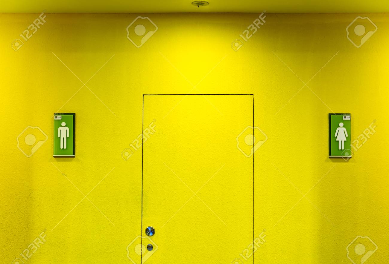トイレ前の黄色い壁に男女の看板や看板が付いています の写真素材 画像素材 Image