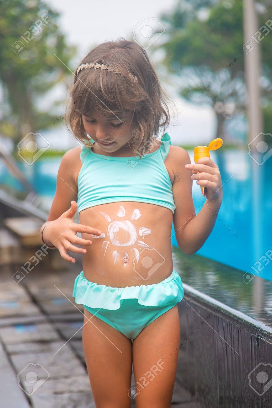 Child on the beach with sunscreen on his back. Selective focus. - 165769090 Child on the beach with sunscreen on his back. Selective focus. - 165769090