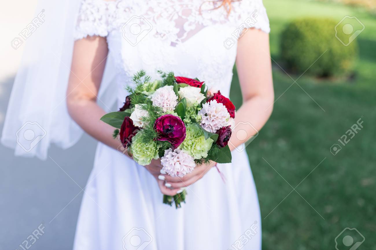 花嫁は白 ピンク 赤の花と緑と結婚式のブーケを保持しています の写真素材 画像素材 Image