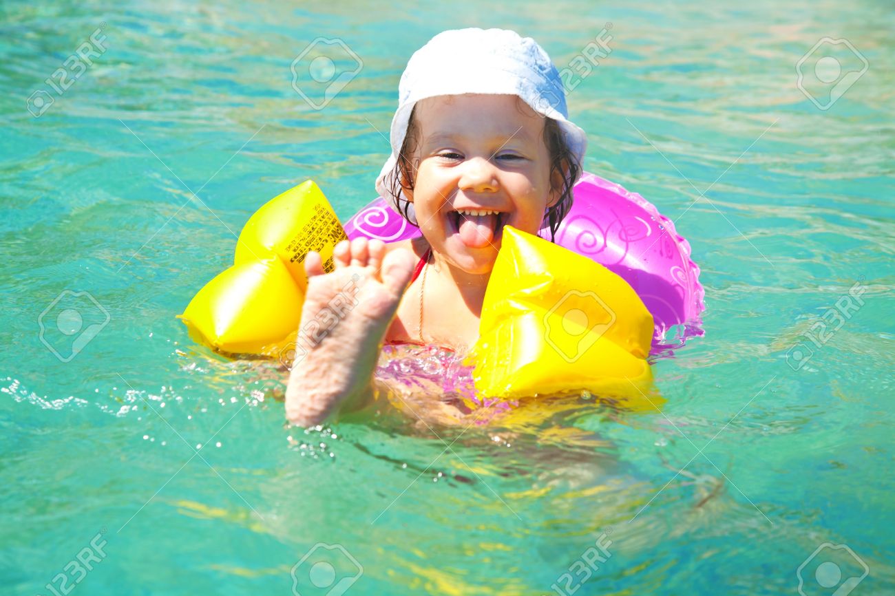 Drole Nage Petite Fille Dans Une Piscine En Jaune Brassards Gonflables Banque D Images Et Photos Libres De Droits Image