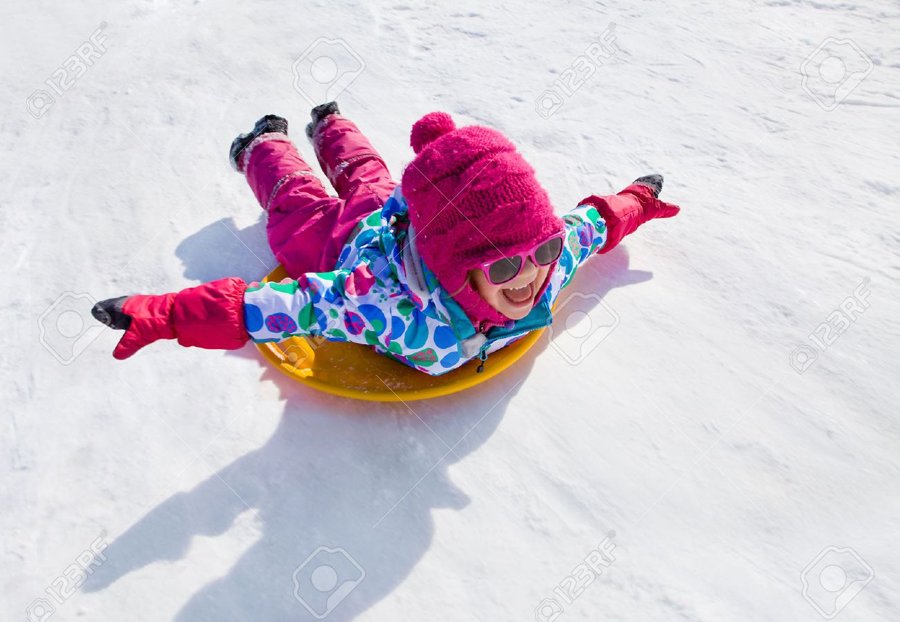 little girl riding on snow slides in winter time - 34267738 little girl riding on snow slides in winter time - 34267738