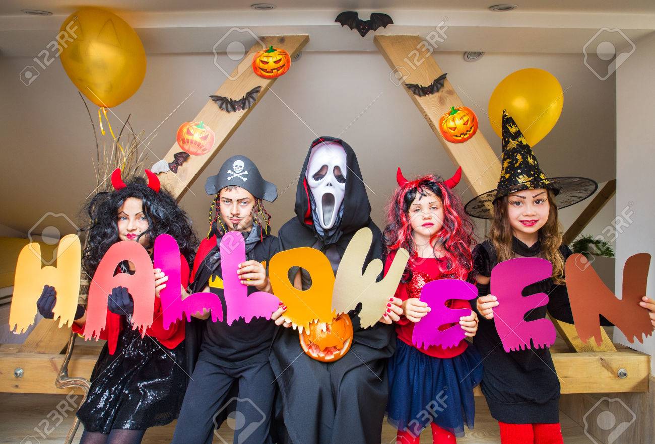 kids in costumes holds the word halloween what is another word for halloween