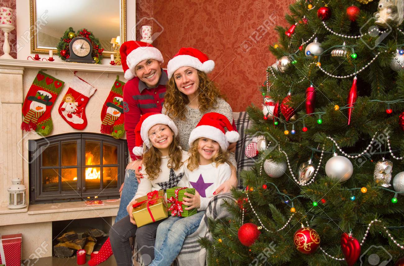 Gluckliche Familie Feiert Weihnachten In Der Nahe Des Kamins Unter Dem Weihnachtsbaum Lizenzfreie Fotos Bilder Und Stock Fotografie Image 90316858