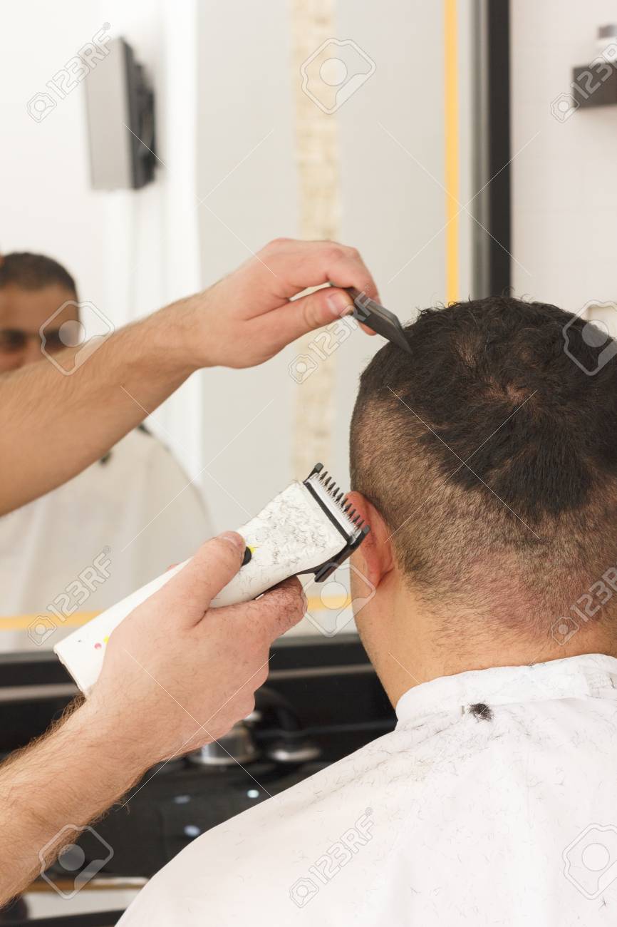 Back View Of Man Getting Short Hair Trimming At Barber Shop With
