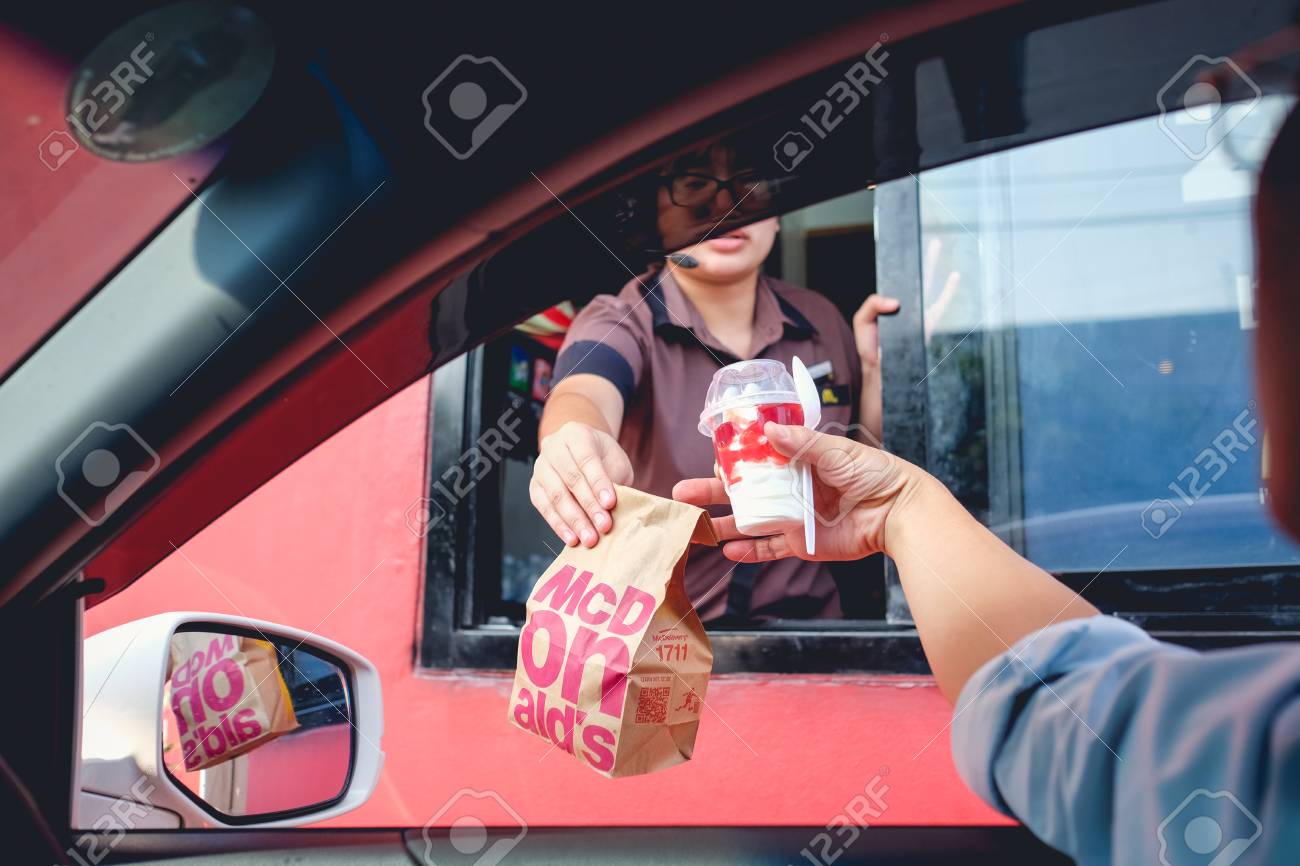 Bangkok, Thailand - Mar 4, 2017: Unidentified customer receiving hamburger and ice cream after order and buy it from McDonald's drive thru service, McDonald's is an American fast food restaurant chain - 92694002 Bangkok, Thailand - Mar 4, 2017: Unidentified customer receiving hamburger and ice cream after order and buy it from McDonald's drive thru service, McDonald's is an American fast food restaurant chain - 92694002