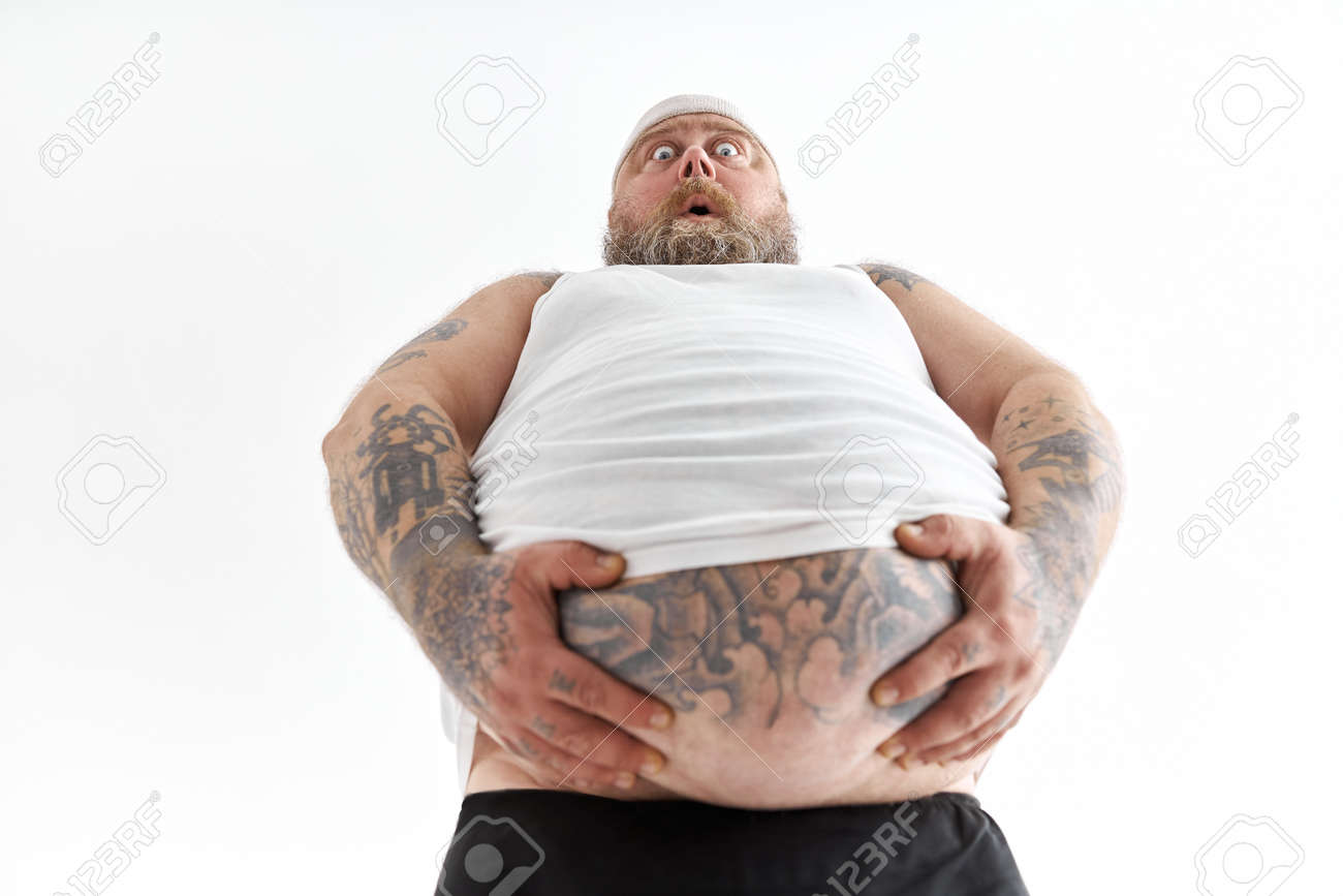 Un Hombre Gordo Con Una Gran Barriga Y Tatuajes En Ropa Deportiva Sostiene  Su Estómago Con Una Emoción Conmocionada Fotos, retratos, imágenes y  fotografía de archivo libres de derecho. Image 172199830