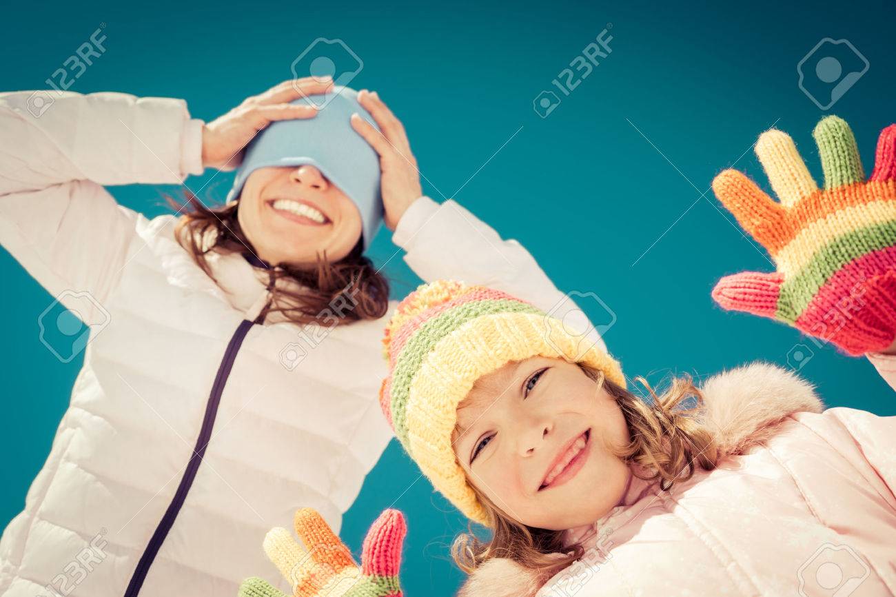Happy family having fun outdoors in winter against blue sky background - 48654721 Happy family having fun outdoors in winter against blue sky background - 48654721