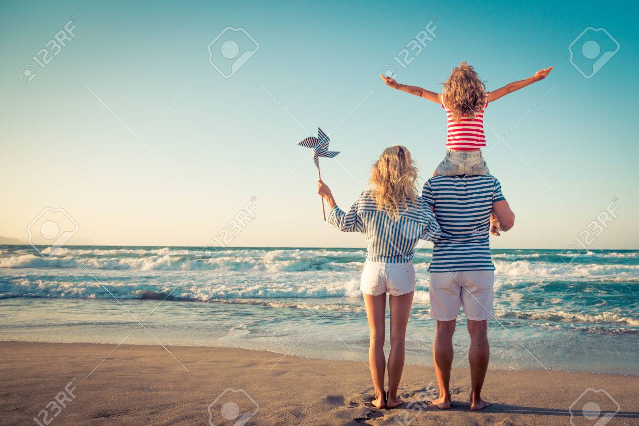 Happy family on the beach. People having fun on summer vacation. Father, mother and child against blue sea and sky background. Holiday travel concept - 79035672 Happy family on the beach. People having fun on summer vacation. Father, mother and child against blue sea and sky background. Holiday travel concept - 79035672