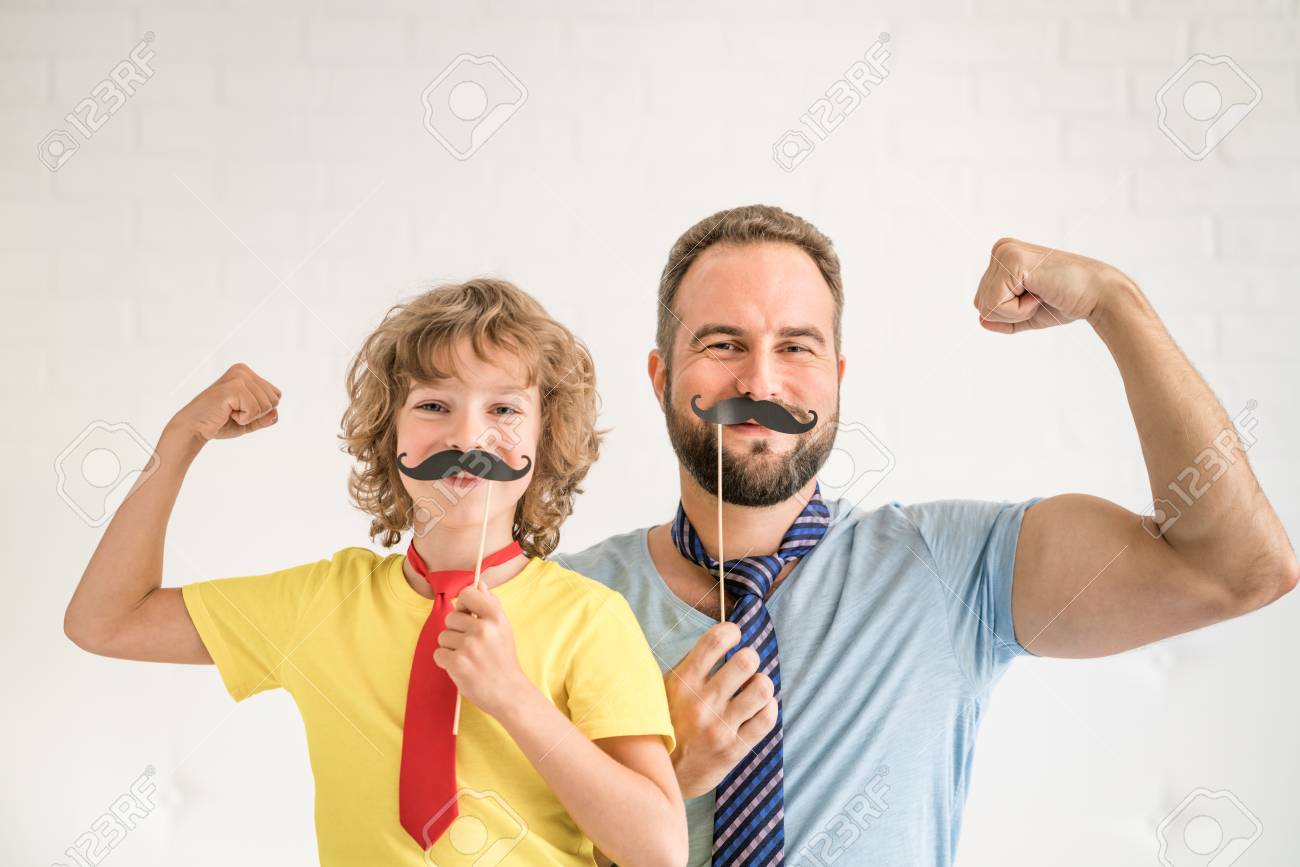 Funny man and kid with fake mustache. Happy family playing in home - 87262495 Funny man and kid with fake mustache. Happy family playing in home - 87262495