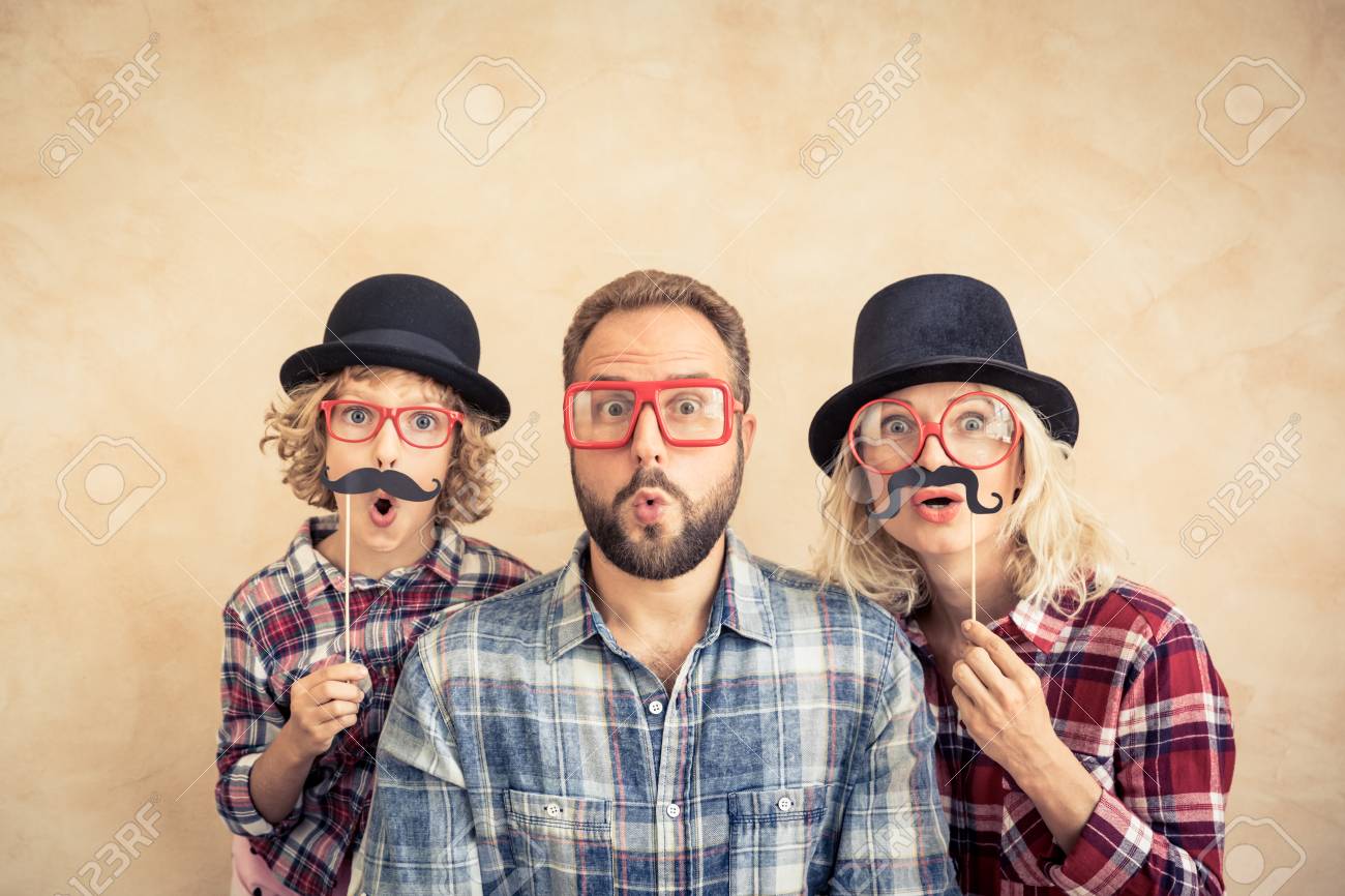 Funny man, woman and kid with fake mustache. Happy family playing in home - 87916390 Funny man, woman and kid with fake mustache. Happy family playing in home - 87916390