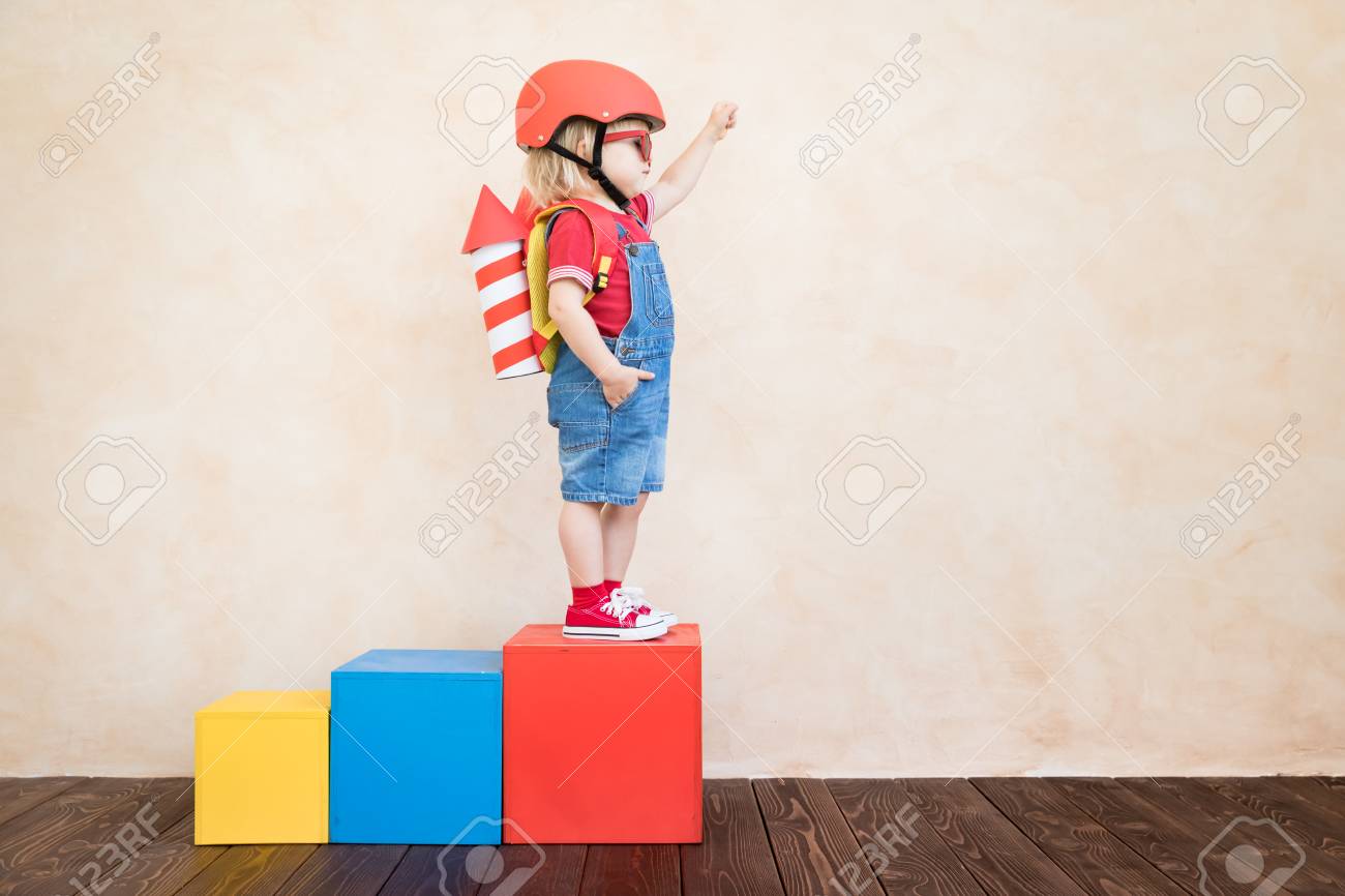 Kid with toy paper rocket. Child playing at home. Success, imagination and innovation technology concept - 119706112 Kid with toy paper rocket. Child playing at home. Success, imagination and innovation technology concept - 119706112