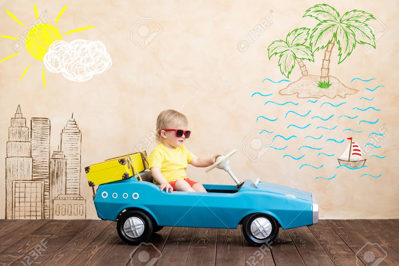 Happy child riding toy vintage car. Funny kid playing at home. Summer vacation and travel concept - 120982108 Happy child riding toy vintage car. Funny kid playing at home. Summer vacation and travel concept - 120982108