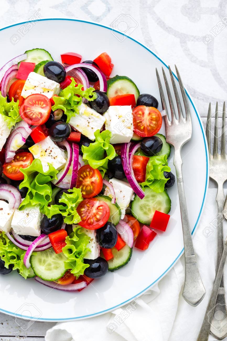 新鮮なキュウリ トマト 甘いコショウ レタス 赤玉ねぎ フェタチーズ オリーブオイルのオリーブのギリシャサラダ ヘルシーなベジタリアン料理 の写真素材 画像素材 Image