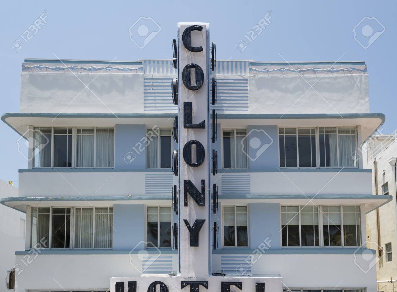 colony hotel facade pastel colored art deco building in daytime the