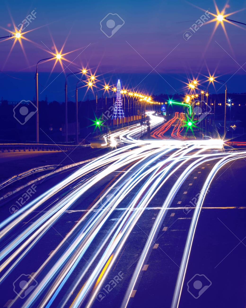 Traces of headlights from cars moving at night on the bridge, illuminated by lanterns. Abstract city landscape with highway at dusk. - 154893188 Traces of headlights from cars moving at night on the bridge, illuminated by lanterns. Abstract city landscape with highway at dusk. - 154893188