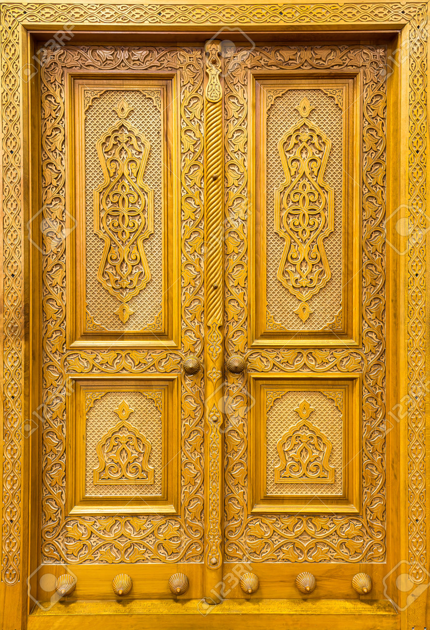 模様とモザイクの彫刻が施されたアンティークの木製ドア。デザインの  