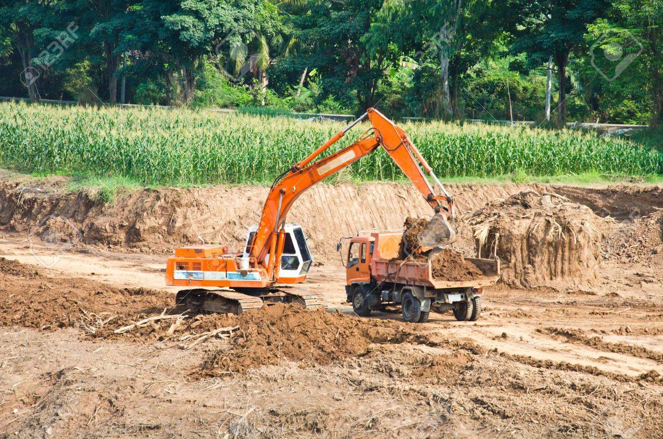 Heavy excavator loader at soil moving works at construction site - 12308309 Heavy excavator loader at soil moving works at construction site - 12308309