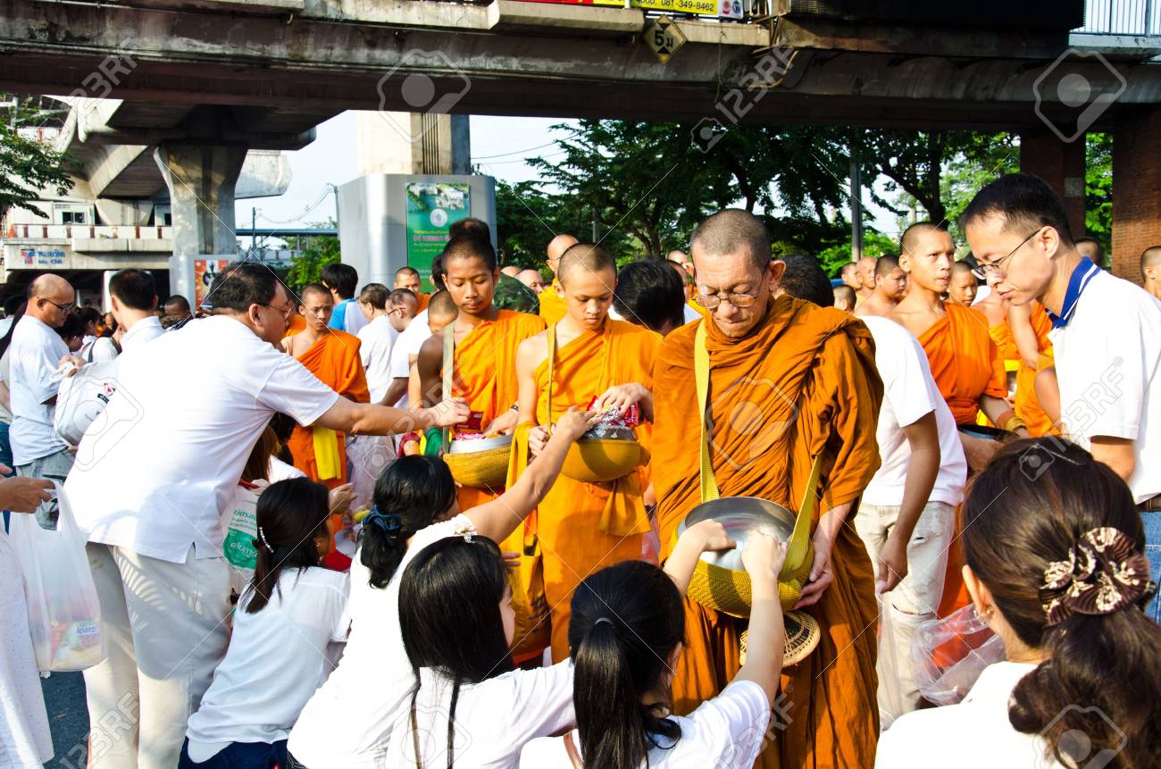BANGKOK , THAILAND - MARCH 17: People Gives food offerings to a Buddhist monk on March 17, 2012 in Bangkok, Thailand. Thai traditional, people will make merit making by give food to monk - 12716992 BANGKOK , THAILAND - MARCH 17: People Gives food offerings to a Buddhist monk on March 17, 2012 in Bangkok, Thailand. Thai traditional, people will make merit making by give food to monk - 12716992