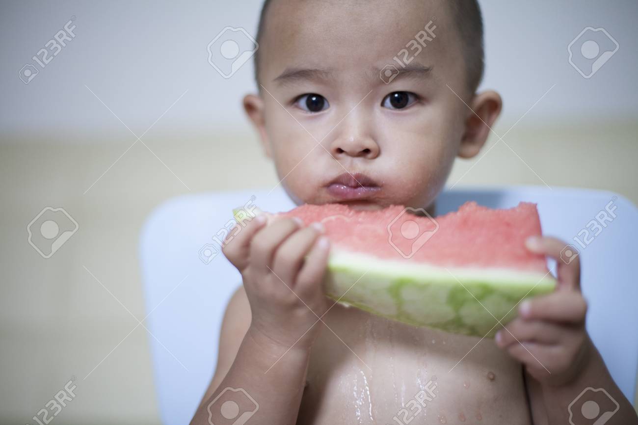 ハッピー中国語赤ちゃん男の子の屋内では スイカを食べる北京 中国 の写真素材 画像素材 Image