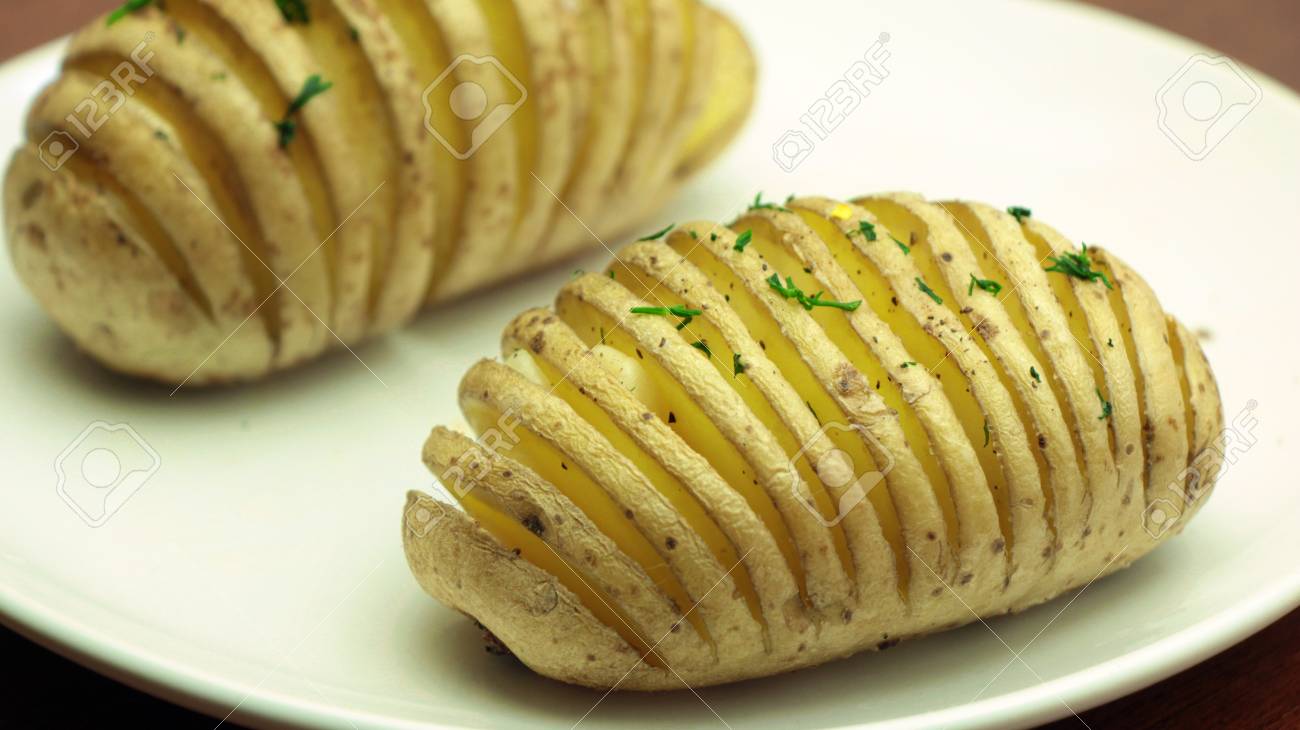 ディル 伝統的なスウェーデンのスライスを振りかけた Hasselback ポテト焼き白皿にポテト の写真素材 画像素材 Image
