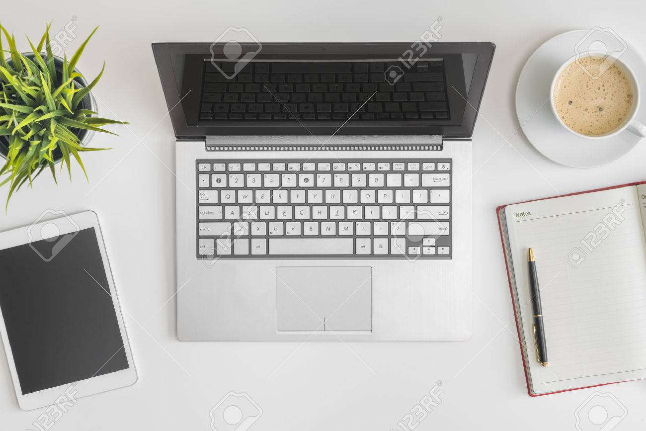 Flat lay photo of office desk with laptop, tablet, notebook and coffee - 52654692 Flat lay photo of office desk with laptop, tablet, notebook and coffee - 52654692
