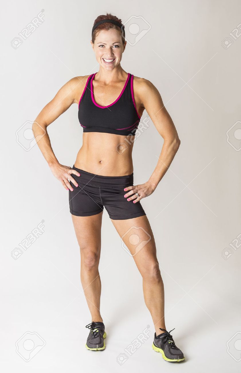 全長カメラを見て美しい強い筋肉女性の肖像画 彼女の腰に手を深刻な女性の身体のビルダー の写真素材 画像素材 Image