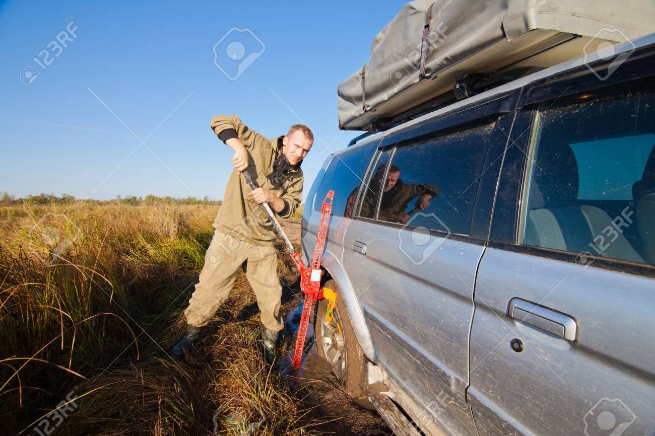 こんにちはジャックで Stucked 車を持ち上げる男 の写真素材 画像素材 Image