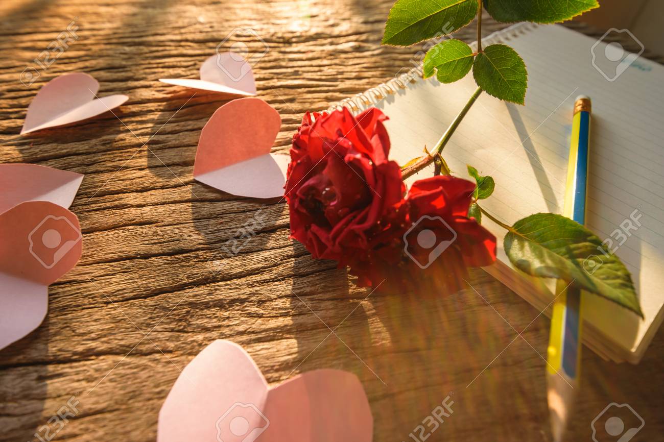 writing note love red rose and note and pencil on old wooden