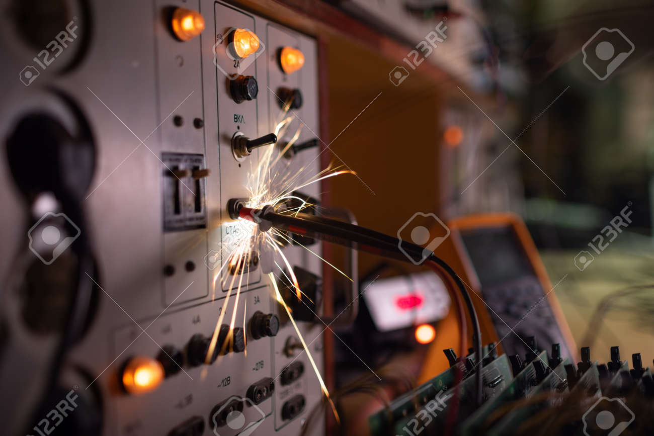 電化製品のある暗い部屋で、複雑な技術機器の危険な短絡から、明るく危険な電流の電子火花がすばやく急激に散乱しますの写真素材・画像素材 Image  181729097