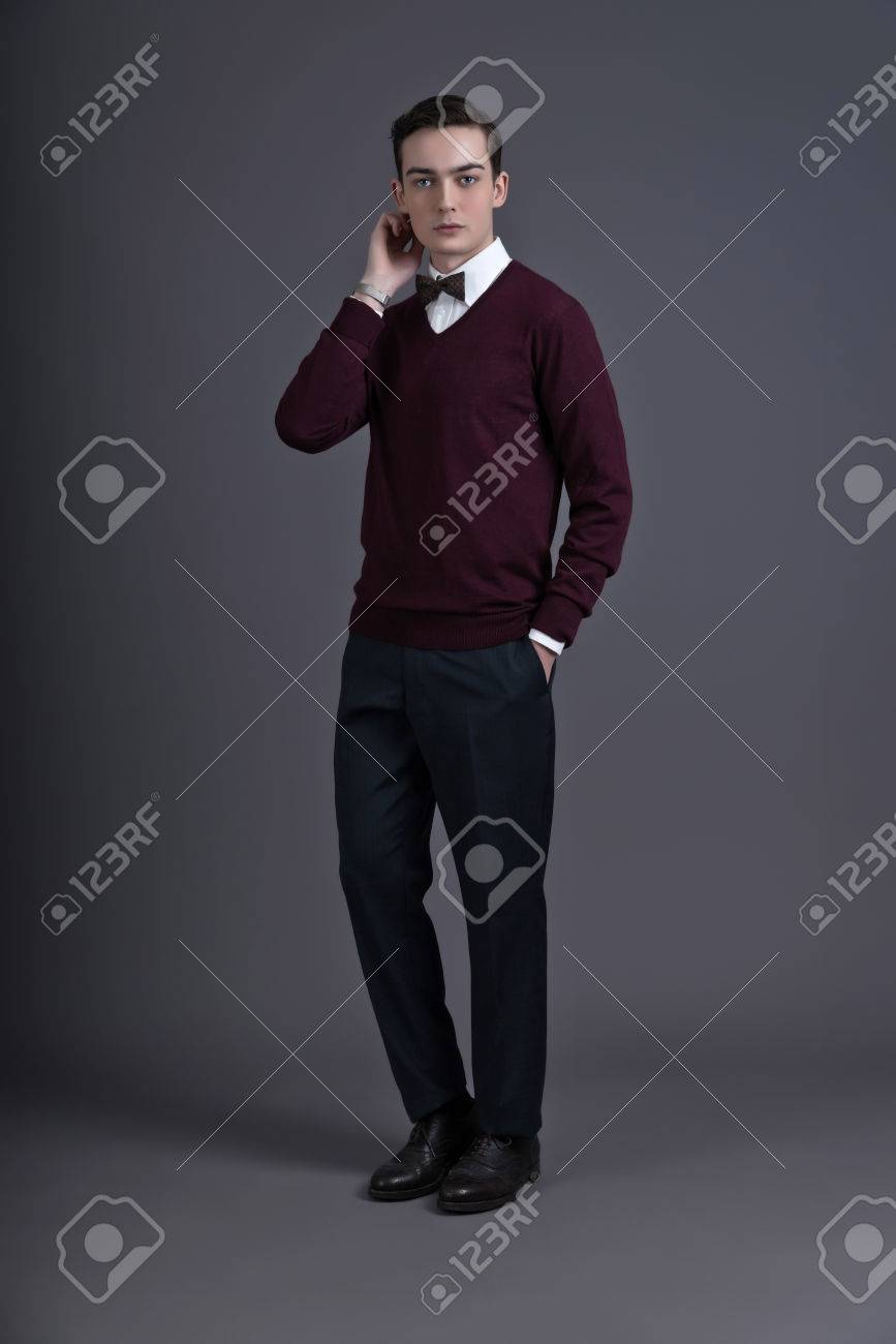 英国スタイルのレトロな 50 年代ファッション若い男 暗い赤シャツと蝶ネクタイを着用します グレーに撮影スタジオ の写真素材 画像素材 Image