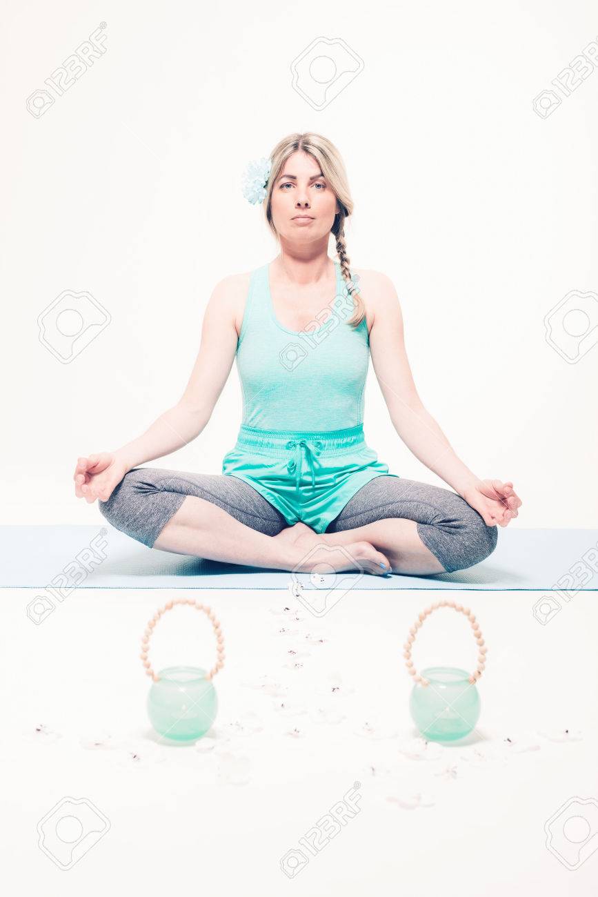 Young Blond Peaceful Woman Meditating In Seated Yoga Lotus Position On Mat With Two Candle Holder Pots And Trail Of Daisy Flowers 正版图像123rf中国 高质量免版税图像库 Image