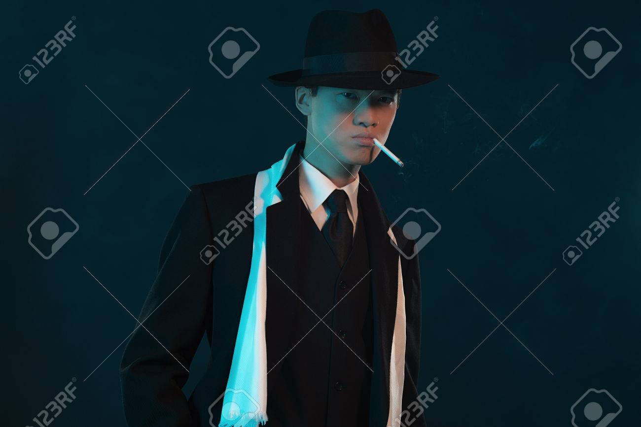 retro 1940 asian gangster fashion man smoking cigarette stock