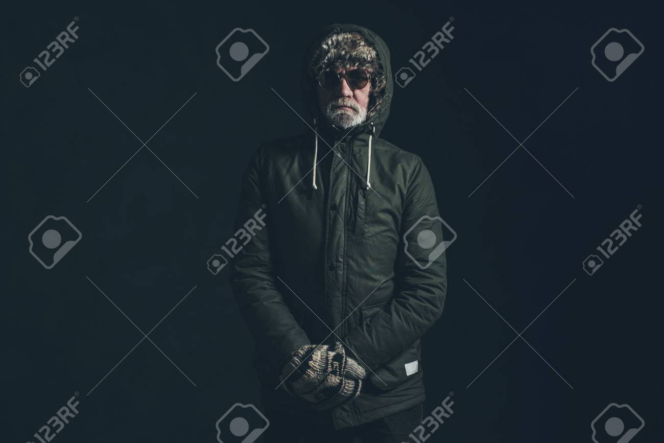 Senior Homme Avec Une Barbe Grise Portant Un Manteau Vert Homme portant un manteau d'hiver avec une capuche de