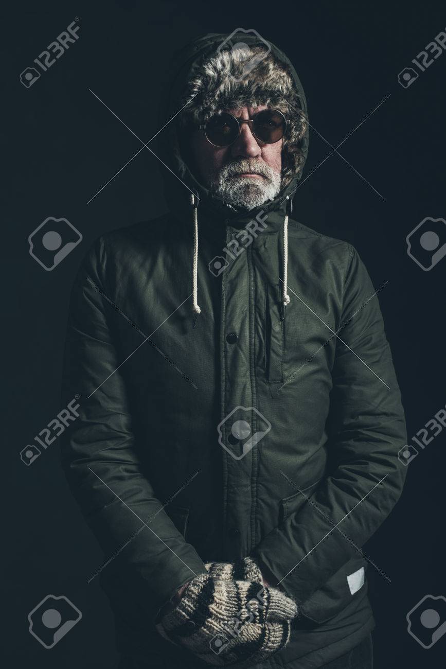 Senior Homme Avec Une Barbe Grise Portant Un Manteau Vert Homme portant un manteau d'hiver avec une capuche de