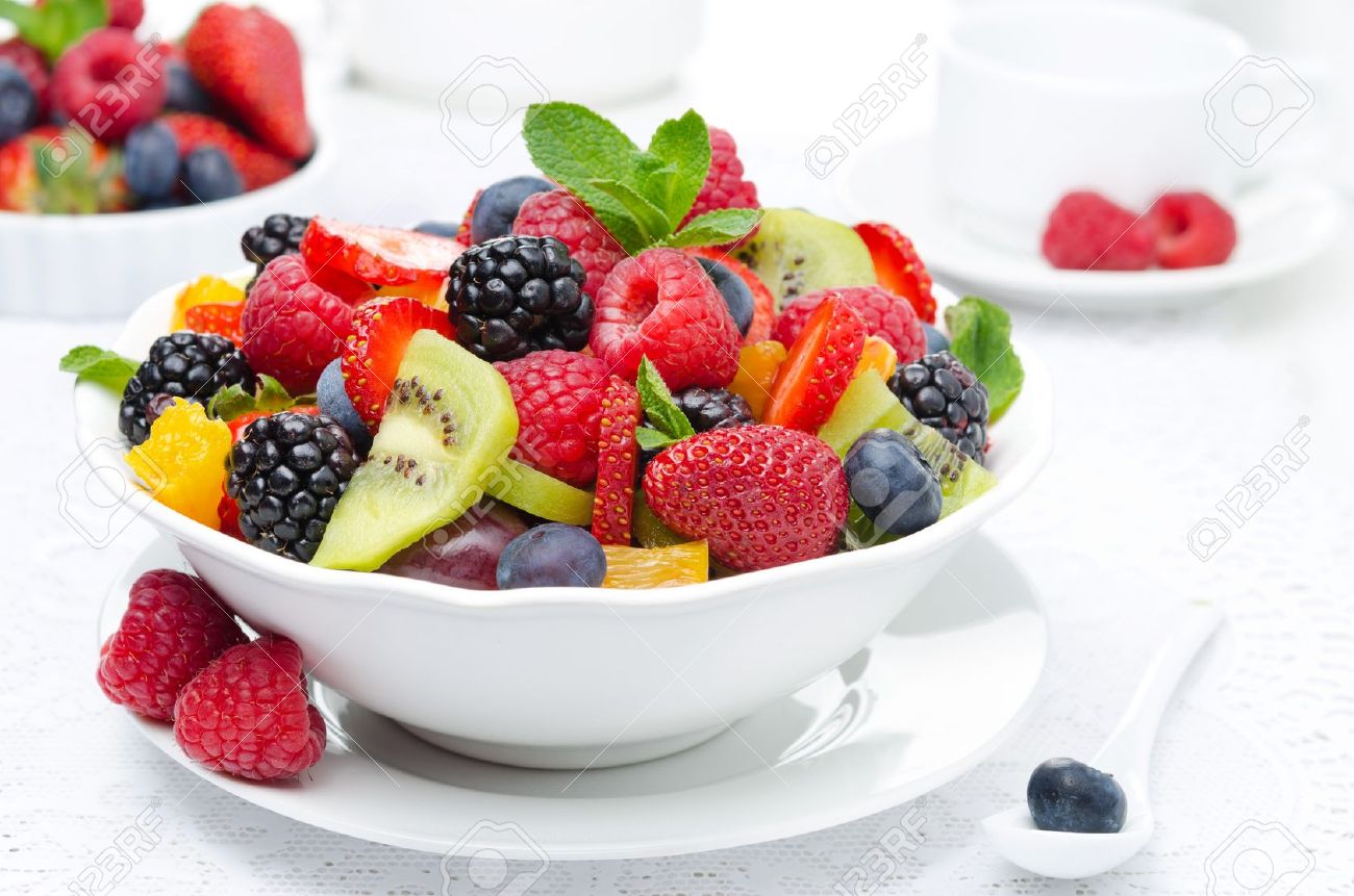 salad of fresh fruit and berries in a white bowl, berries and a cup of tea in the background, horizontal closeup - 19579497 salad of fresh fruit and berries in a white bowl, berries and a cup of tea in the background, horizontal closeup - 19579497
