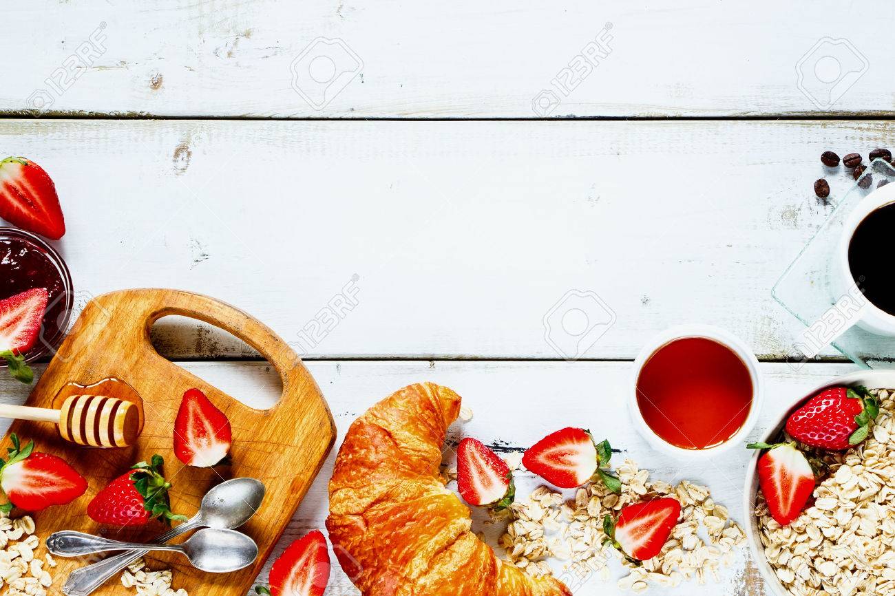 Delicious rural breakfast with oats, fresh strawberries, cup of coffee, fruity jam, honey and croissant on rustic white wooden background with space for text. Top view. - 54733150 Delicious rural breakfast with oats, fresh strawberries, cup of coffee, fruity jam, honey and croissant on rustic white wooden background with space for text. Top view. - 54733150