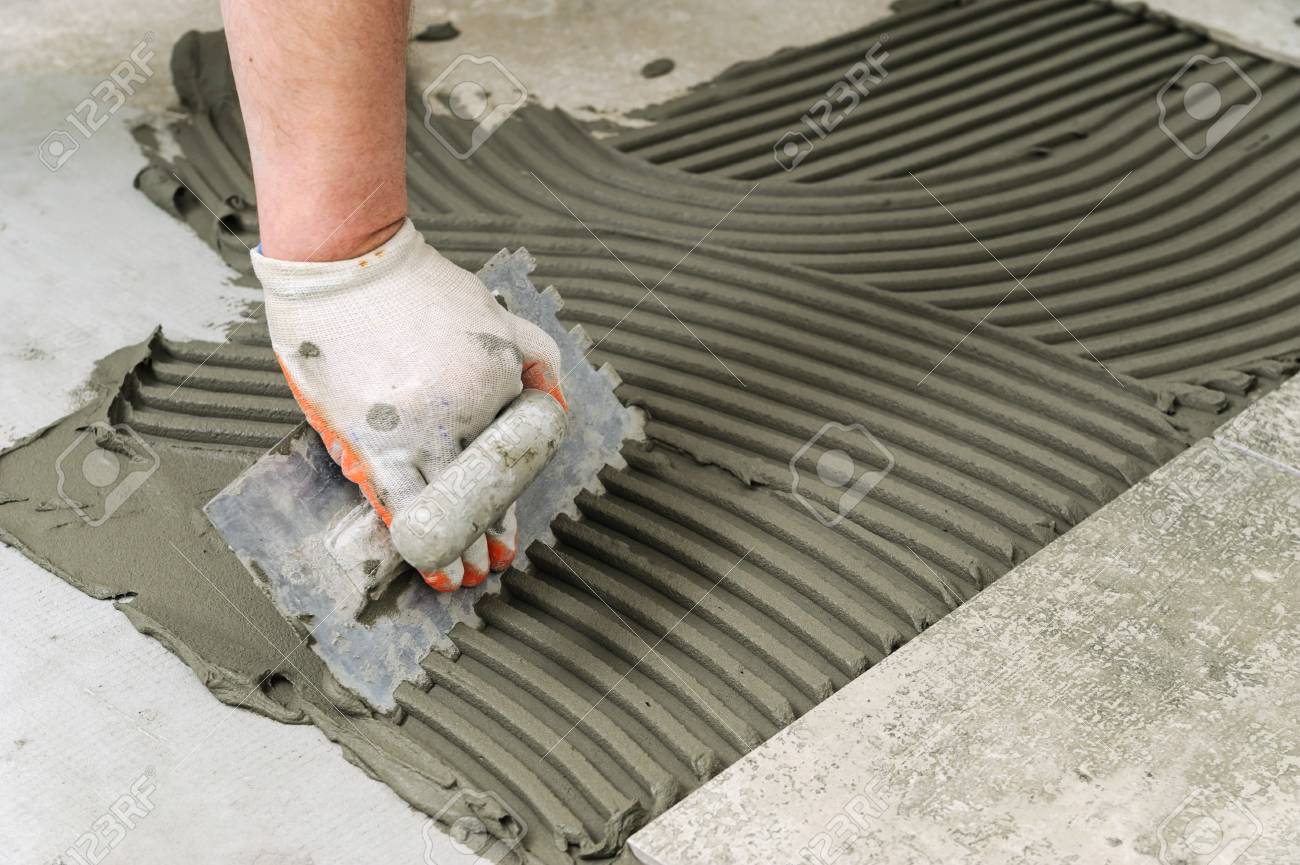 Laying Ceramic Tiles Troweling Mortar Onto A Concrete Floor