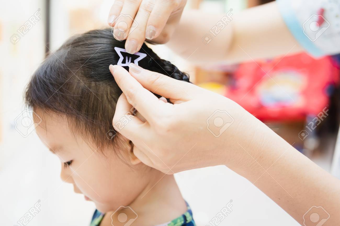 Asian Lady Weaving Braids Hair For Child Little At Home Stock