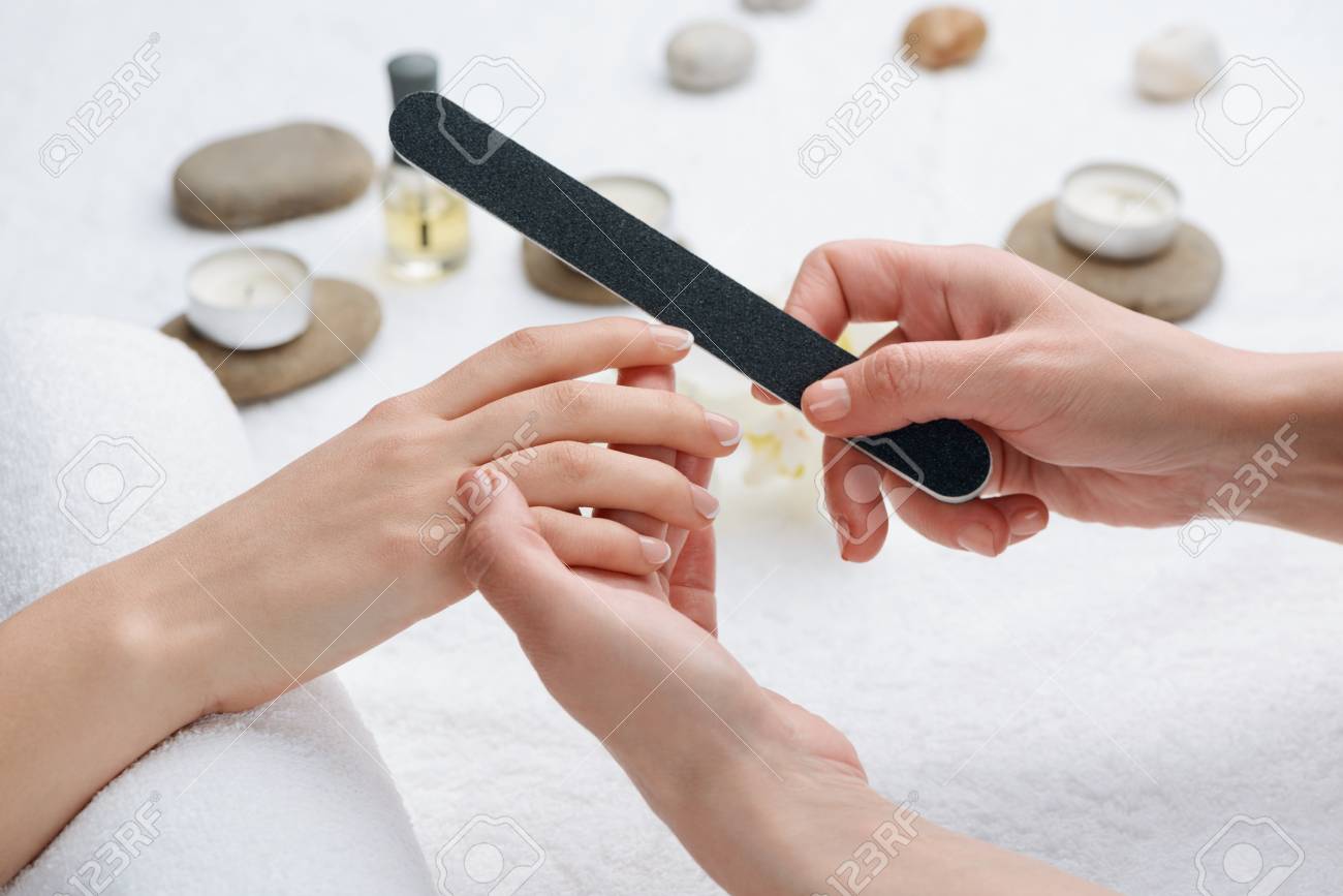 Manicurist Grinding Nails With A File 