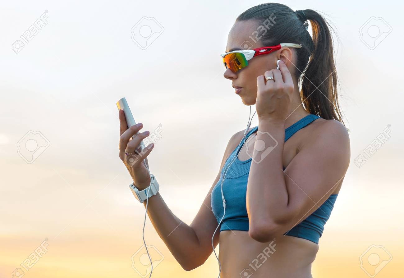 Mujer Corriente En Gafas De Sol Deportivas Corredor Femenino Con Su Teléfono Inteligente Entrenamiento De Entrenamiento Al Aire Libre En La Playa Hermosa Modelo De Fitness De Raza Mixta En Forma Al