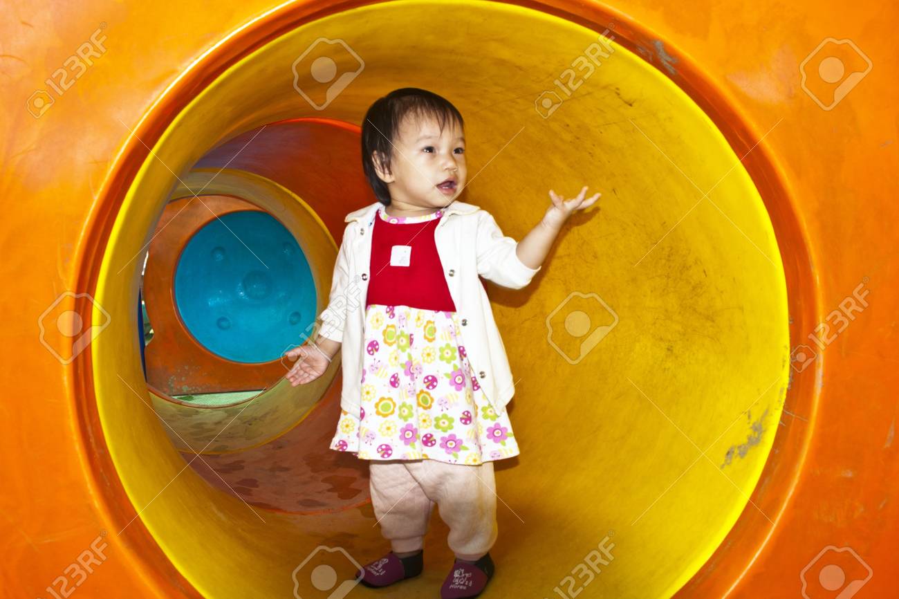 遊び場のトンネル内の小さな女の赤ちゃん の写真素材 画像素材 Image