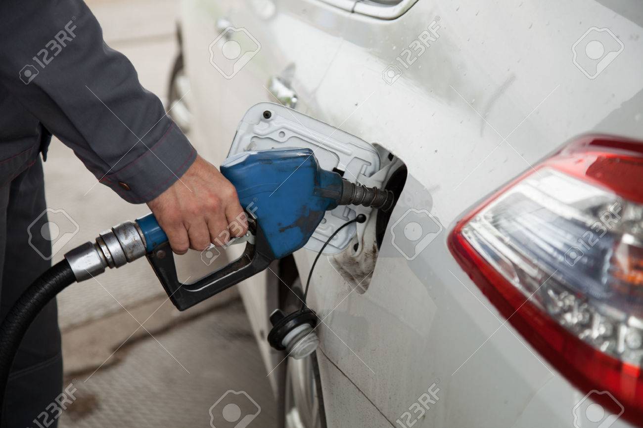 Male hand pumping petrol into car, refueling with nozzle at gas station - 42489613 Male hand pumping petrol into car, refueling with nozzle at gas station - 42489613