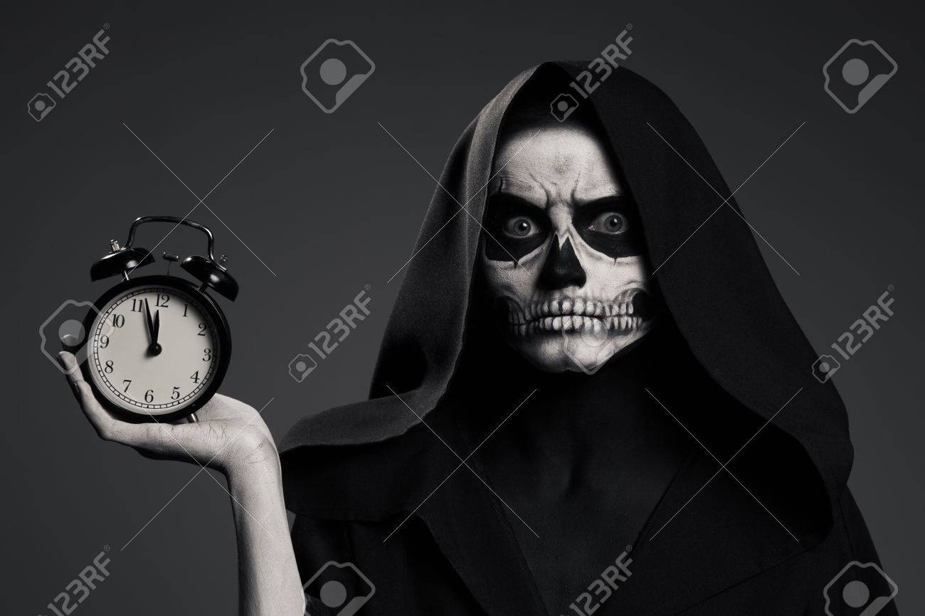 怖い死は 彼の手で時計を保持します リアルなスカルのメイク の写真素材 画像素材 Image