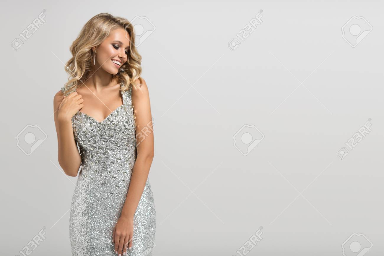Beautiful woman in shining silver dress on gray background. - 88777017 Beautiful woman in shining silver dress on gray background. - 88777017