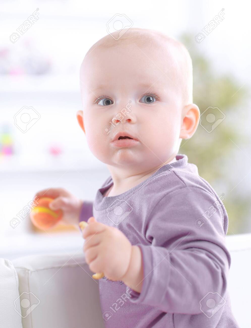close up.cute baby eating a cookie while sitting on the couch - 123600968 close up.cute baby eating a cookie while sitting on the couch - 123600968